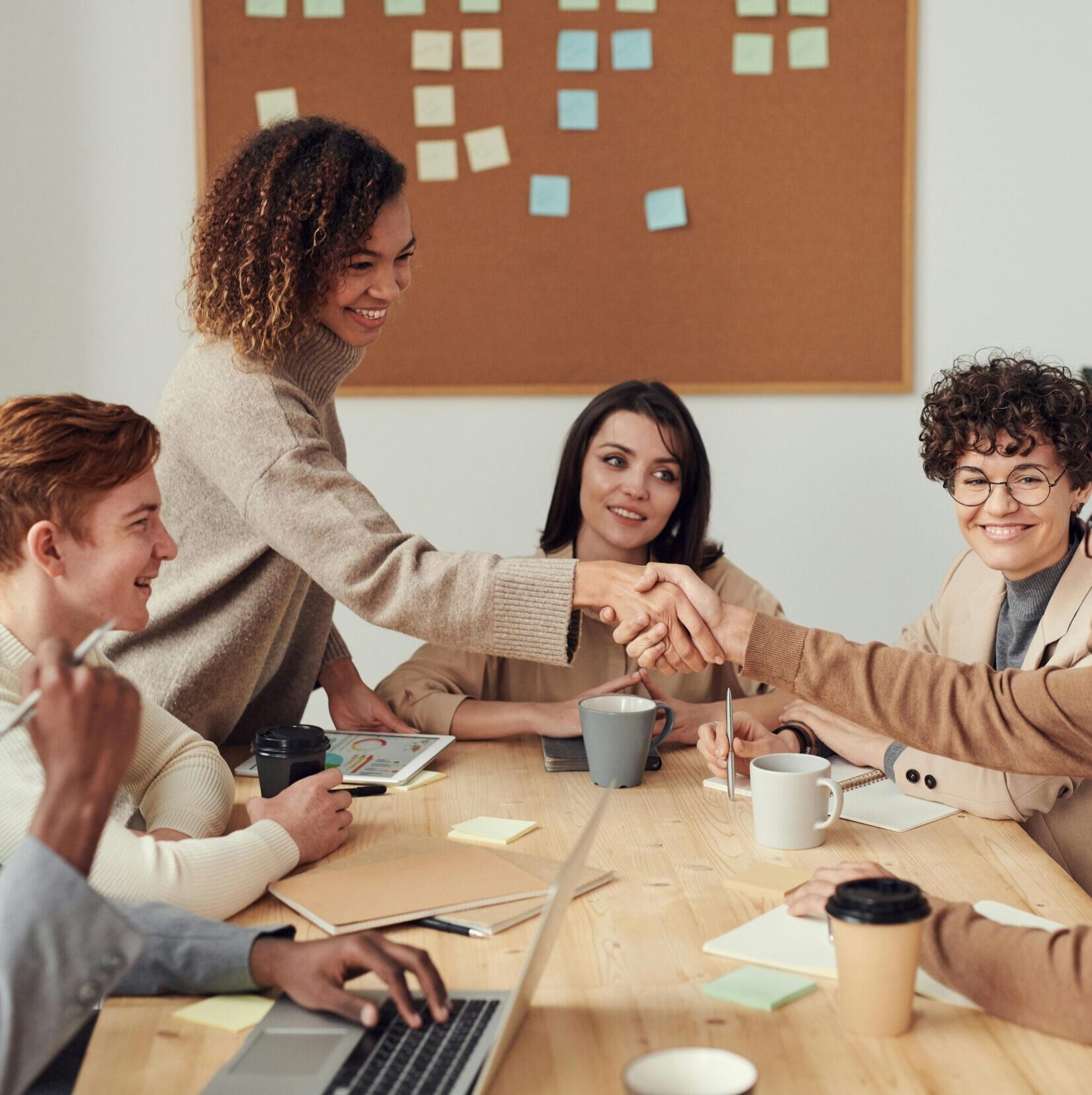 Diverse team collaborating in a meeting, showcasing teamwork and cooperation in a modern workplace.